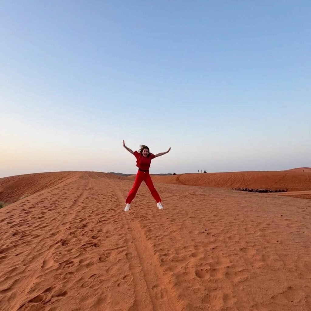 Joyful traveler jumping in the Sahara dunes on 5 Days Tour from Marrakech to Merzouga