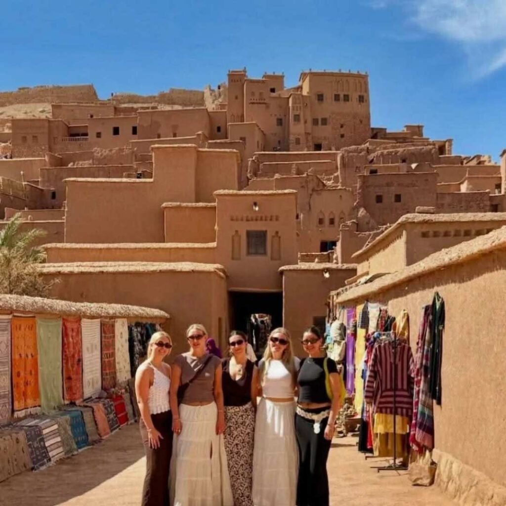 Group of travelers exploring the historic site of Ait Ben Haddou on a 5 Days Tour from Marrakech to Fes.