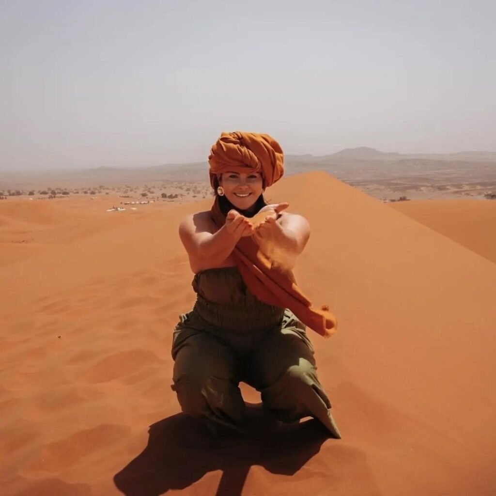 Traveler in traditional Berber attire enjoying the Sahara Desert on a 5 Days Tour from Marrakech to Fes.