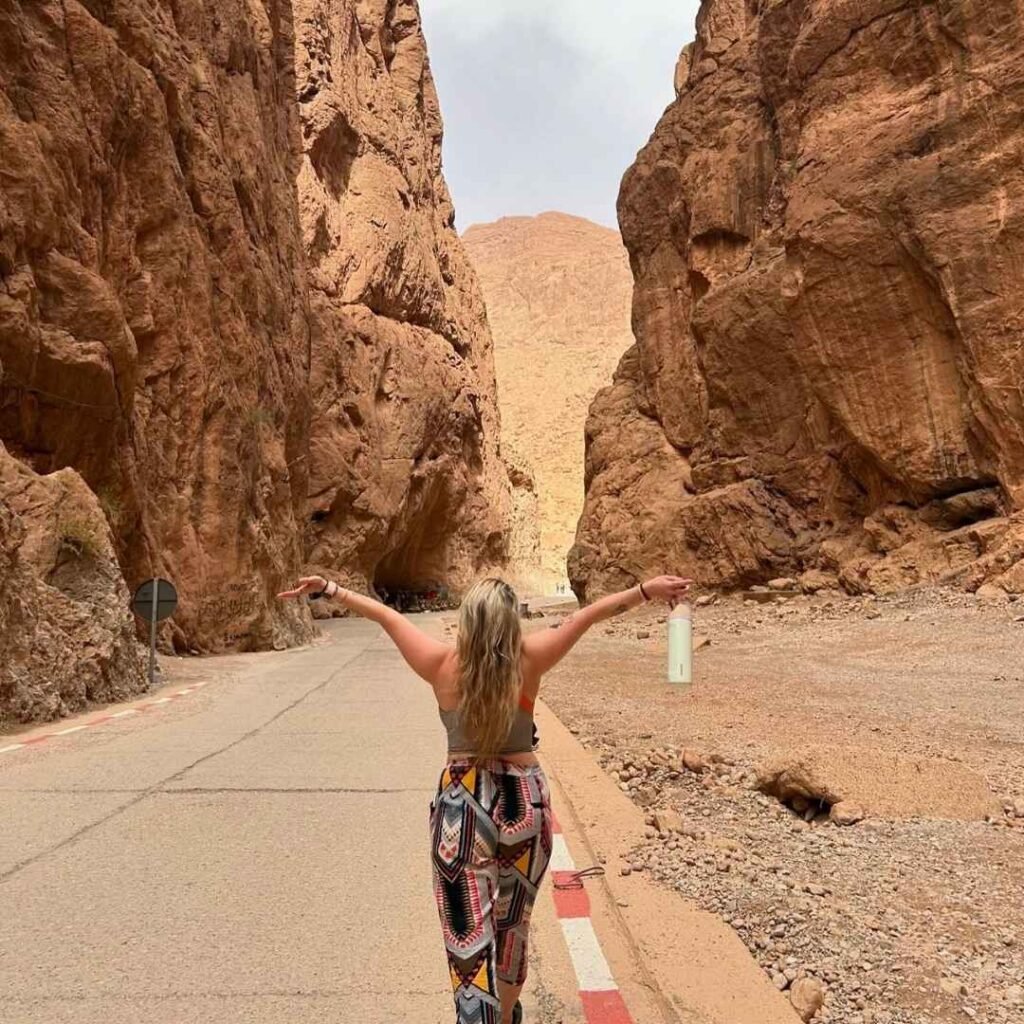 Traveler exploring the towering rock walls of Todra Gorge on a 5 Days Tour from Marrakech to Fes.