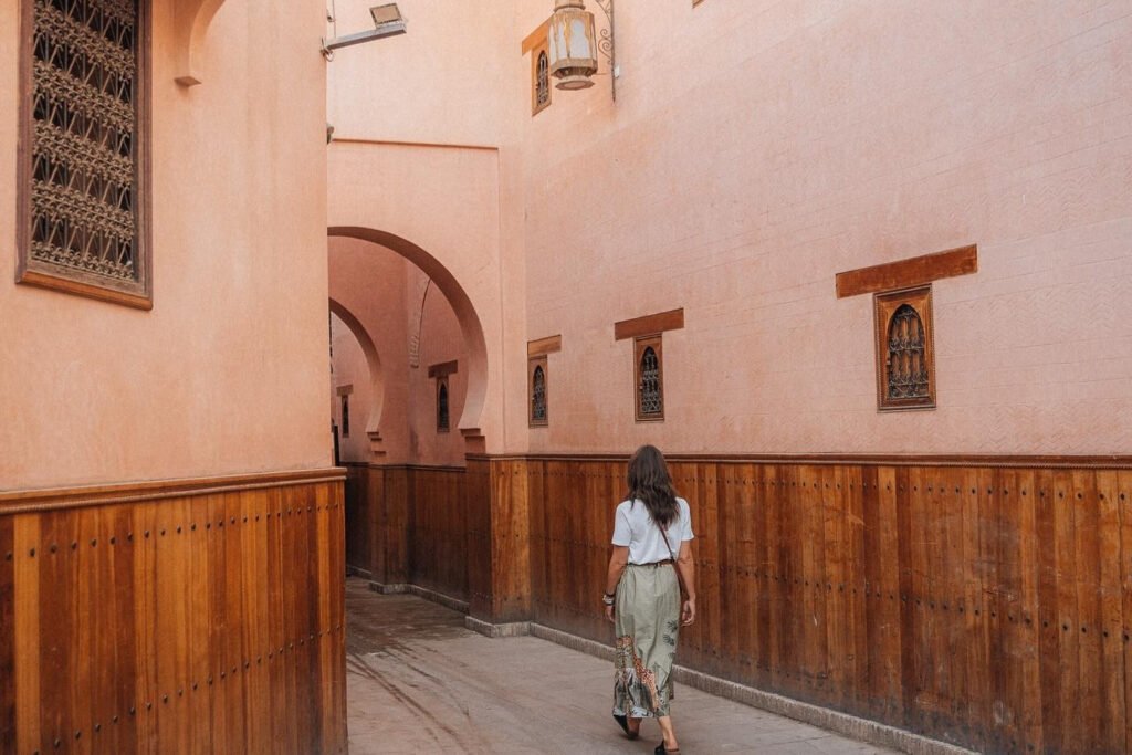 Exploring the Best Area to Stay in Marrakech – Medina Streets Woman walking through narrow alleyway in the Medina, the best area to stay in Marrakech for cultural immersion