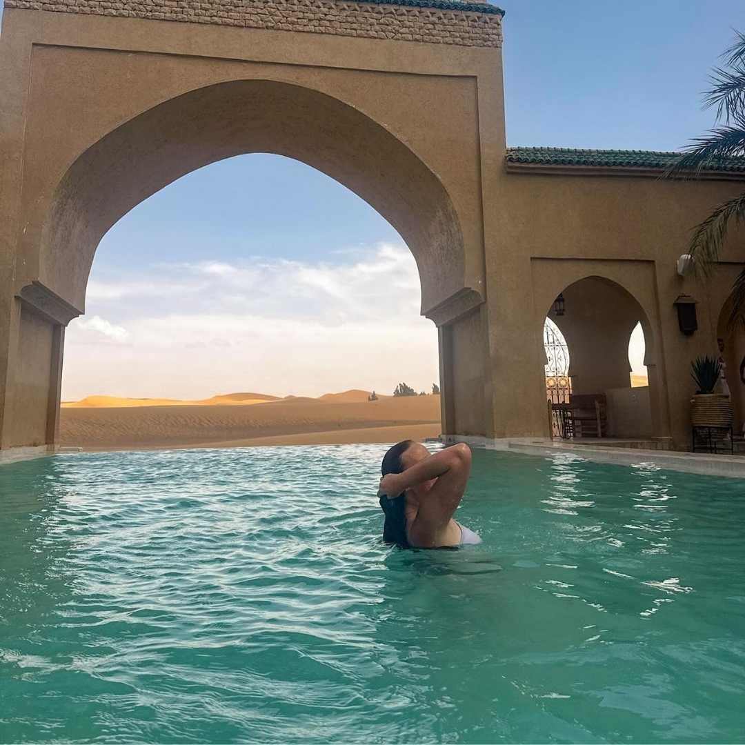 Relaxing in a luxury desert pool during a premium tour with the Best Morocco Tours Agency.